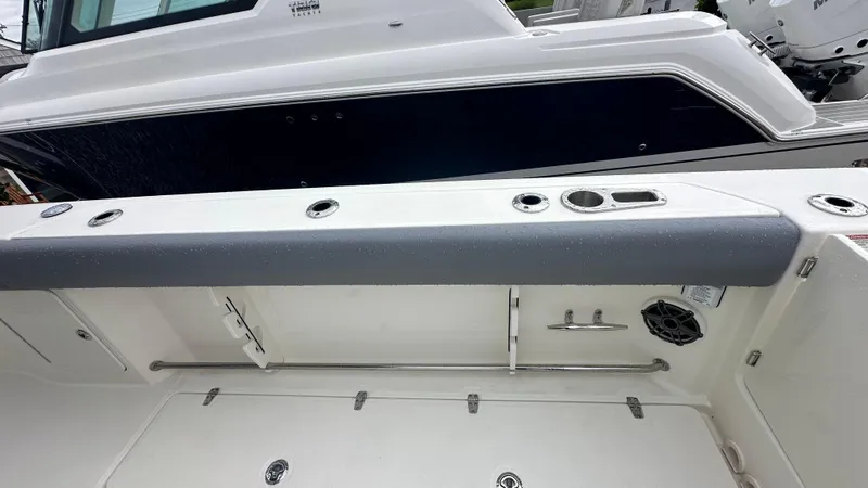 Slide: The Image of 2025 Boston Whaler 330 Outrage boat interior with rod holders and storage compartments. - 11