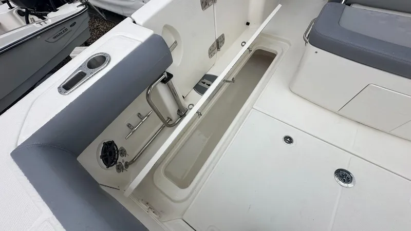Slide: The Image of 2025 Boston Whaler 330 Outrage interior storage compartment and seating area. - 13
