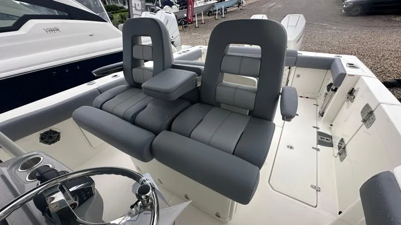 Slide: The Image of 2025 Boston Whaler 330 Outrage boat interior with gray seating and steering wheel. - 18