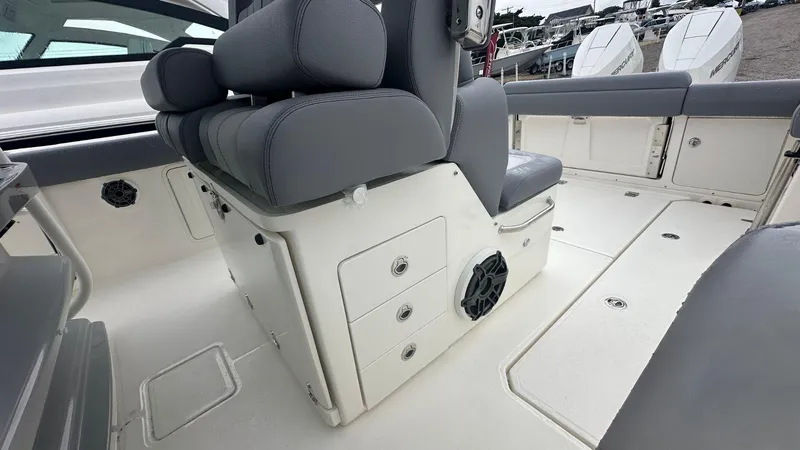 Slide: The Image of 2025 Boston Whaler 330 Outrage interior with gray seating and storage compartments. - 21