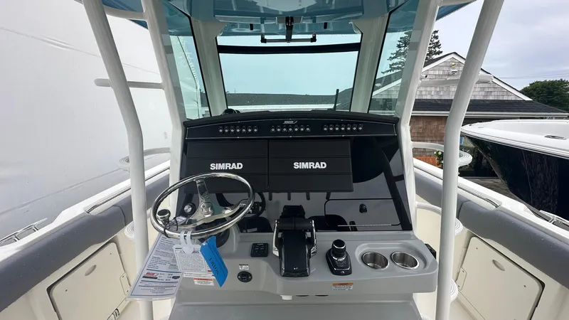 Slide: The Image of 2025 Boston Whaler 330 Outrage helm with Simrad electronics and modern controls. - 24