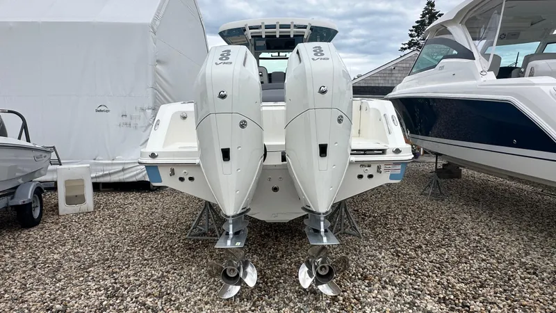 Slide: The Image of 2025 Boston Whaler 330 Outrage with dual outboard engines, displayed on gravel. - 3