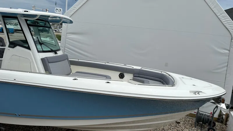 Slide: The Image of 2025 Boston Whaler 330 Outrage boat with blue hull and cushioned seating. - 41