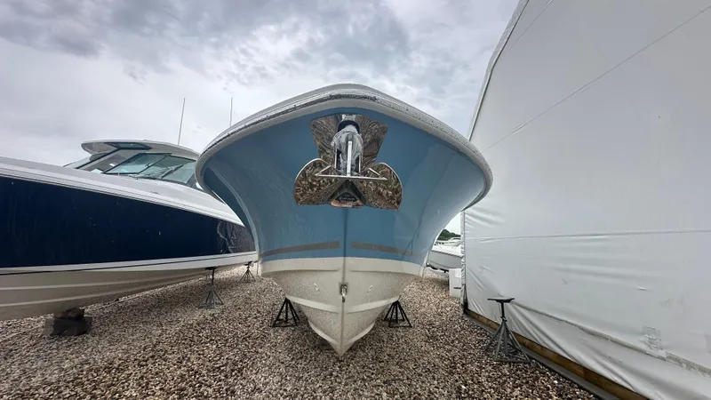 Slide: The Image of 2025 Boston Whaler 330 Outrage boat on dry dock, cloudy sky background. - 42