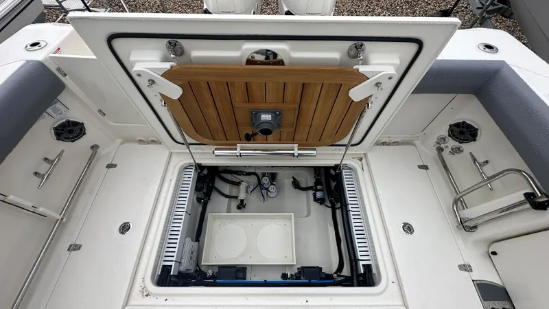 Slide: The Image of 2025 Boston Whaler 330 Outrage boat storage compartment with open hatch and visible equipment. - 8
