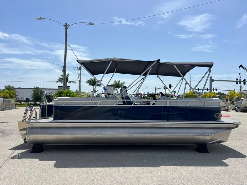Slide: The Image of 2025 Avalon 2385 Venture 85 Quad Lounger Tri Toon boat, parked outdoors under clear sky. - 4