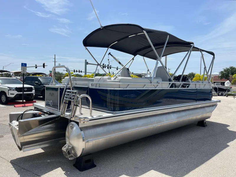 Slide: The Image of 2025 Avalon 2385 Venture 85 Quad Lounger Tri Toon boat with canopy, parked outdoors. - 5