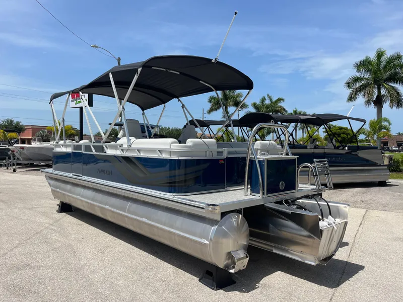 Slide: The Image of 2025 Avalon 2385 Venture 85 Quad Lounger Tri Toon boat with canopy, parked outdoors. - 7