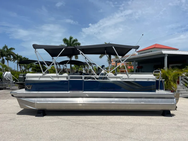 Slide: The Image of 2025 Avalon 2385 Venture 85 Quad Lounger Tri Toon boat, parked outdoors under a clear sky. - 8