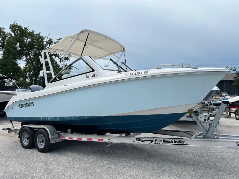 The Image of 2013 Everglades 230 Dual Console boat on trailer, parked outdoors. - 1
