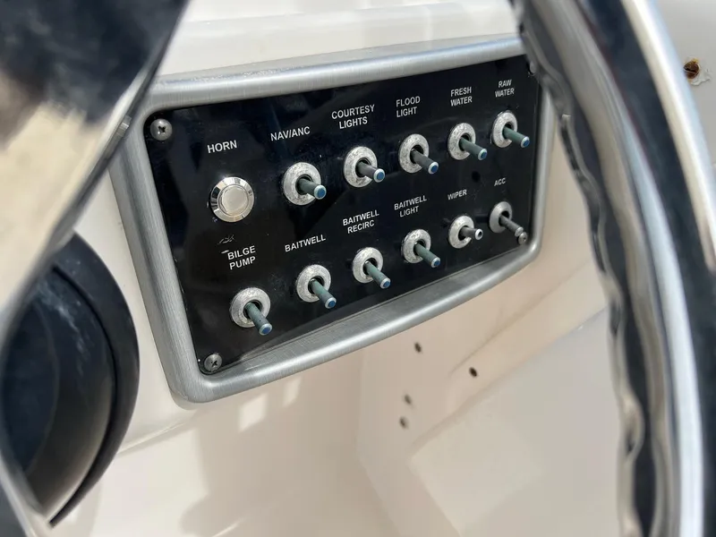 Slide: The Image of Control panel of a 2013 Everglades 230 Dual Console boat with various switches. - 13