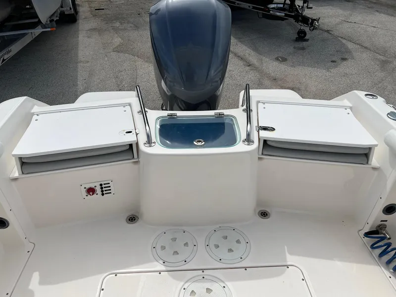 Slide: The Image of 2013 Everglades 230 Dual Console boat deck with storage compartments and outboard motor. - 16