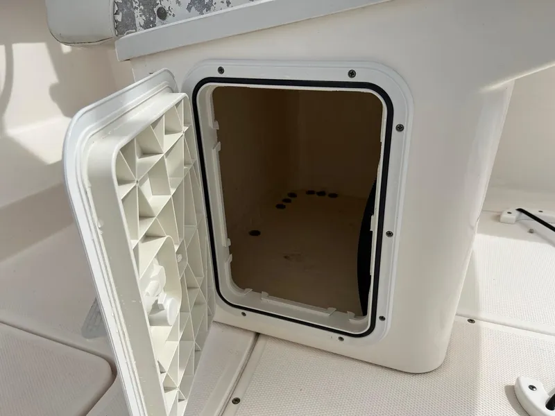 Slide: The Image of Open storage compartment on a 2013 Everglades 230 Dual Console boat. - 18