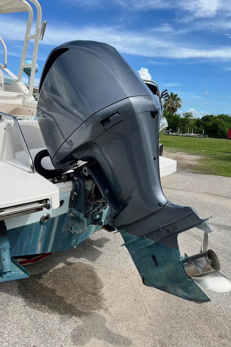 Slide: The Image of Outboard motor on a 2013 Everglades 230 Dual Console boat, parked on pavement. - 22