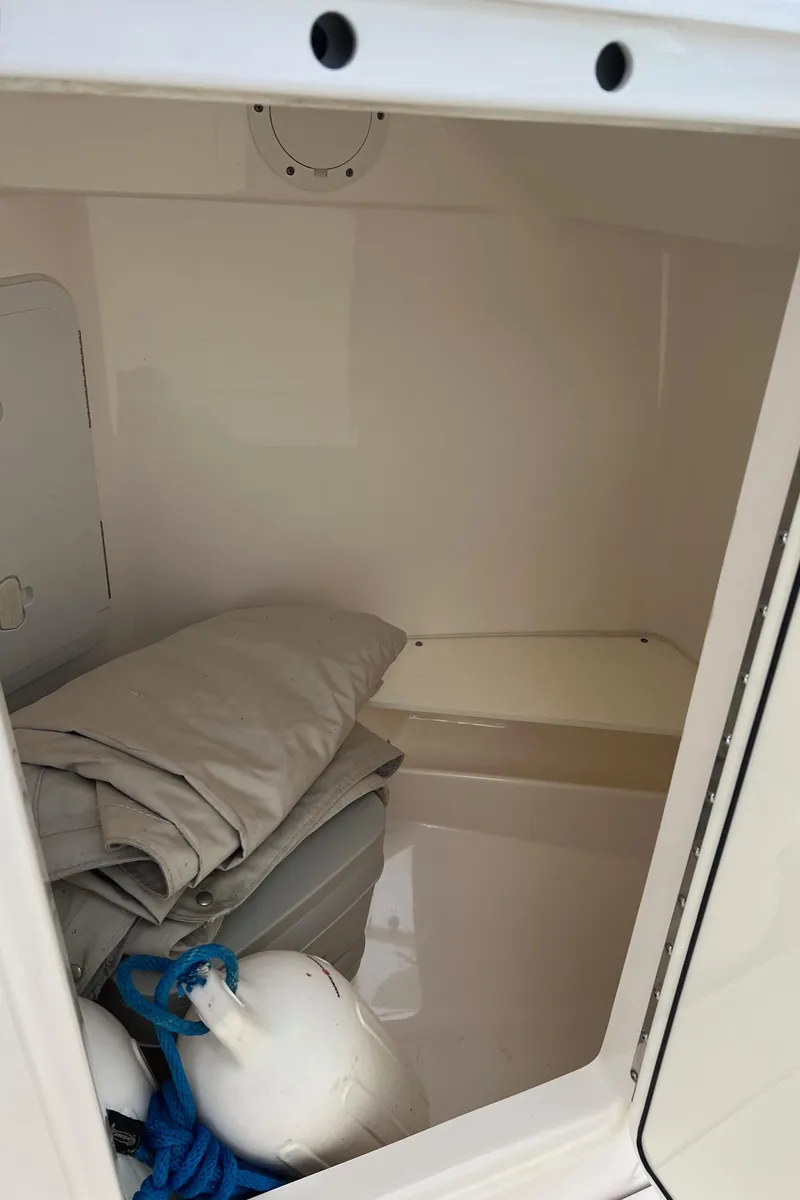 Slide: The Image of Storage compartment of 2013 Everglades 230 Dual Console with folded cover and fender. - 23