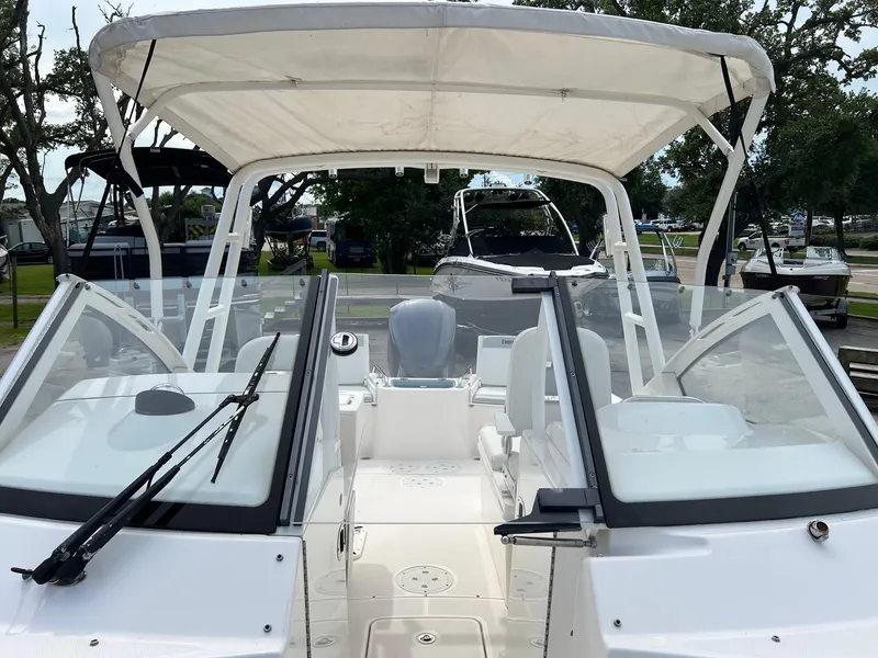 Slide: The Image of 2013 Everglades 230 Dual Console boat with canopy and windshield, docked outdoors. - 6