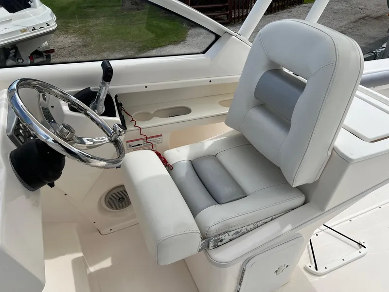 Slide: The Image of Captain's seat and steering wheel of a 2013 Everglades 230 Dual Console boat. - 9