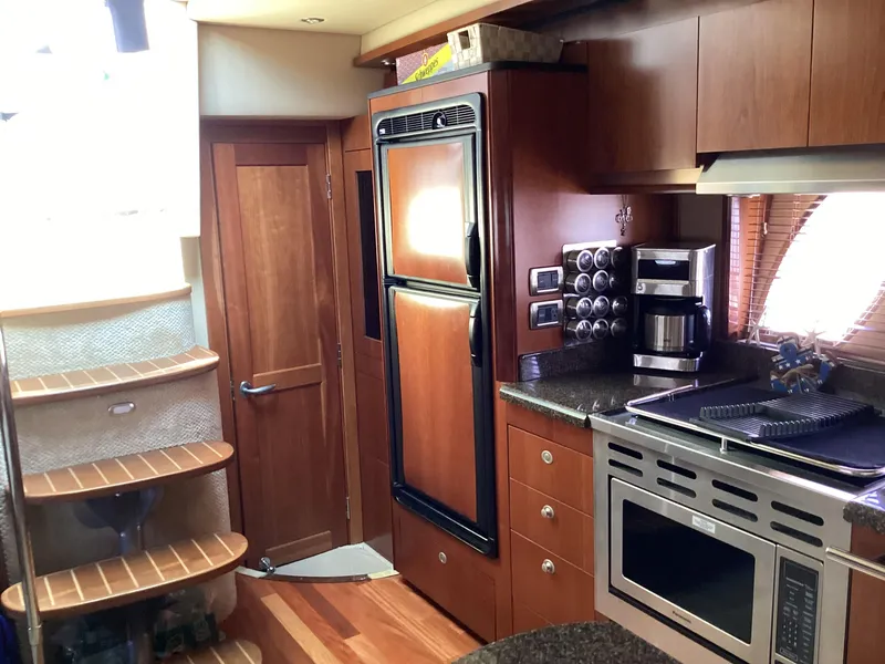 Slide: The Image of Interior of 2006 Sea Ray 48 Sundancer yacht kitchen with wood cabinetry and modern appliances. - 14