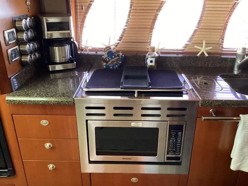 Slide: The Image of Galley kitchen in 2006 Sea Ray 48 Sundancer with microwave, coffee maker, and starfish decor. - 22