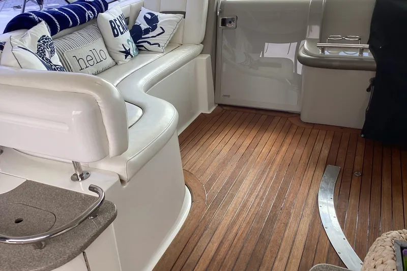 Slide: The Image of Interior of 2006 Sea Ray 48 Sundancer with white seating and nautical-themed pillows. - 35