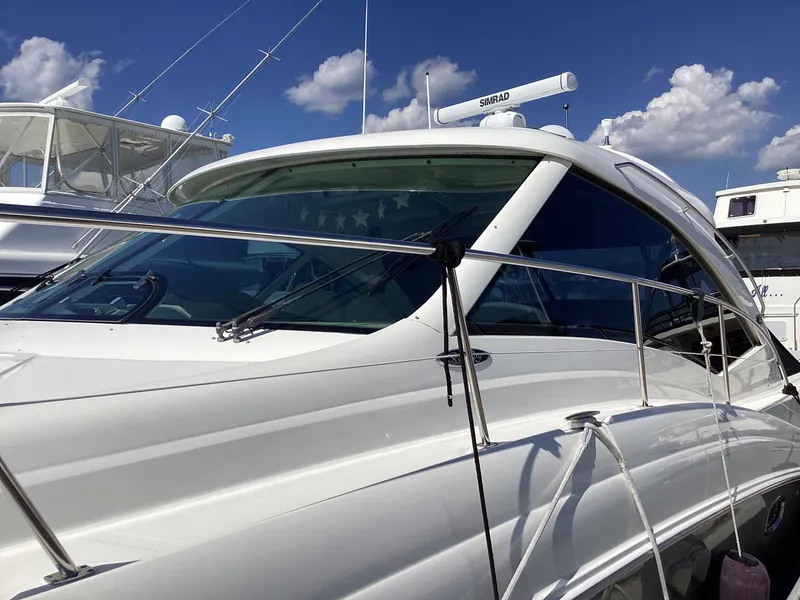 Slide: The Image of 2006 Sea Ray 48 Sundancer yacht with sleek design, docked under a clear blue sky. - 5