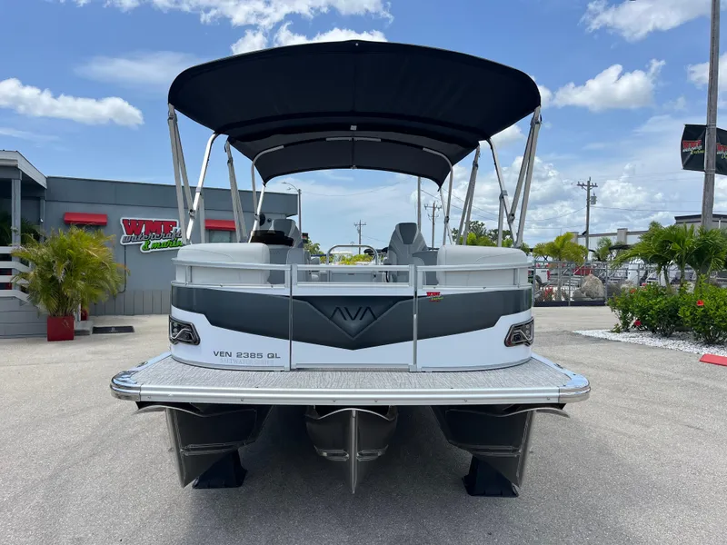 Slide: The Image of 2025 Avalon 2385 Venture Quad Lounger Tri Toon boat, parked outdoors under a blue sky. - 2