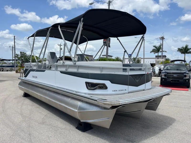 Slide: The Image of 2025 Avalon 2385 Venture Quad Lounger Tri Toon boat with canopy, parked outdoors. - 3