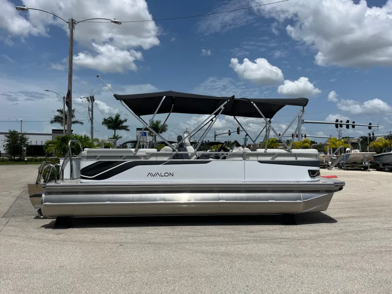 Slide: The Image of 2025 Avalon 2385 Venture 85 Quad Lounger Tri Toon boat under a clear blue sky. - 4