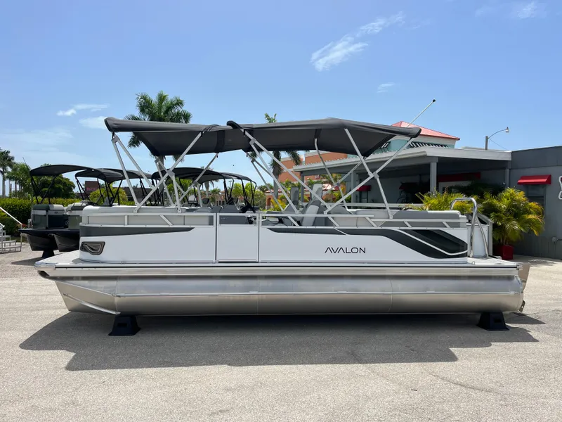 Slide: The Image of 2025 Avalon 2385 Venture 85 Quad Lounger Tri Toon boat, parked outdoors under clear sky. - 8