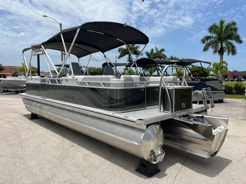 Slide: The Image of 2025 Avalon 2385 Venture 85 Quad Lounger Tri Toon boat, parked outdoors under a clear sky. - 7