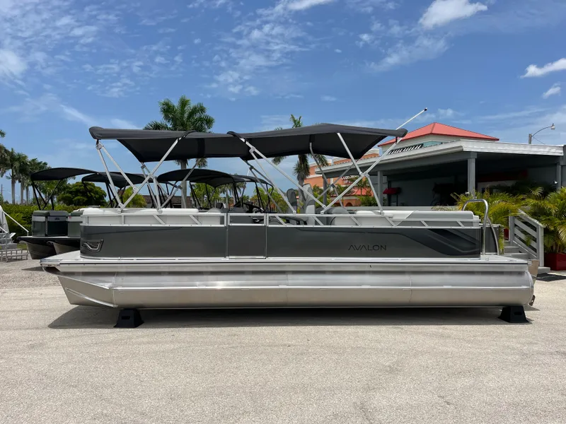 Slide: The Image of 2025 Avalon 2385 Venture 85 Quad Lounger Tri Toon boat, parked outdoors under a blue sky. - 8