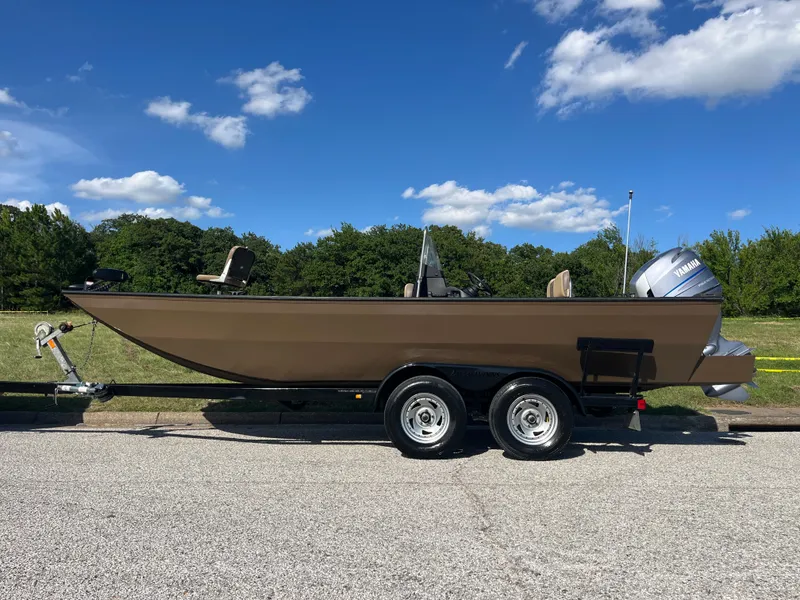 Slide: The Image of 2011 G3 2072cc boat on trailer, parked outdoors under a clear blue sky. - 2