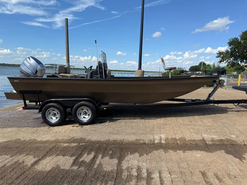 Slide: The Image of 2011 G3 2072cc boat on trailer by a lake under a clear blue sky. - 38
