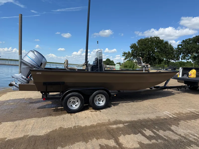 Slide: The Image of 2011 G3 2072cc boat on trailer by the water, clear sky background. - 40