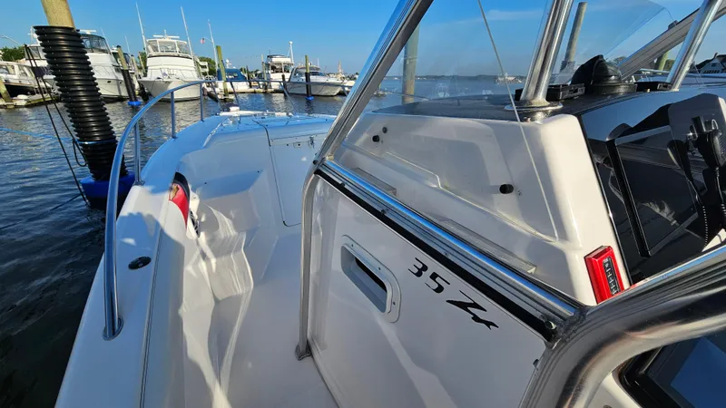 Slide: The Image of 1999 Donzi 35 ZF boat docked at marina, showcasing sleek design and controls. - 17