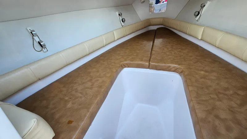 Slide: The Image of Interior of a 1999 Donzi 35 ZF boat with beige seating and storage compartment. - 26