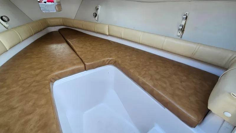 Slide: The Image of 1999 Donzi 35 ZF cabin interior with tan leather seating and white storage compartment. - 27