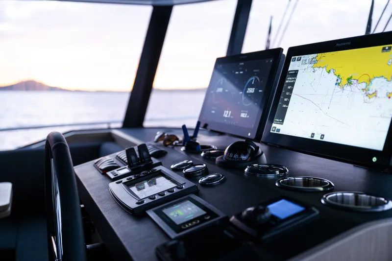 Slide: The Image of Helm of 2026 Beneteau Swift Trawler 54 with advanced navigation displays at sunset. - 10
