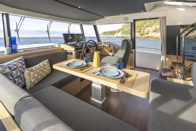 Slide: The Image of Luxurious interior of 2026 Beneteau Swift Trawler 54 with dining area and helm, overlooking the sea. - 12