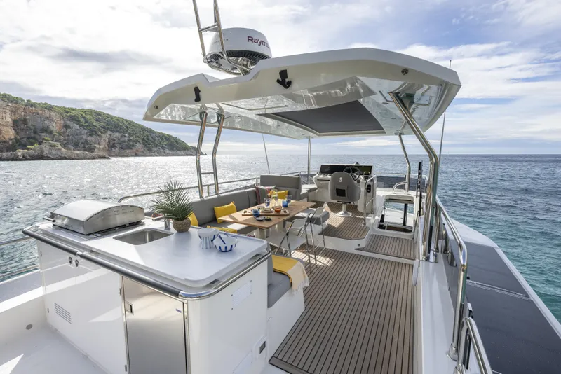 Slide: The Image of Luxurious 2026 Beneteau Swift Trawler 54 yacht with outdoor dining and ocean view. - 21