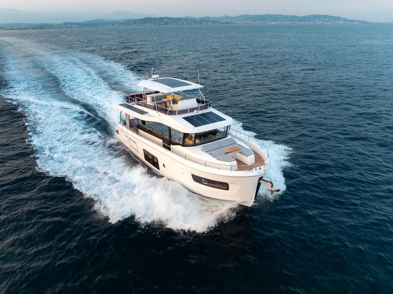Slide: The Image of 2026 Beneteau Swift Trawler 54 cruising on open sea, showcasing sleek design and performance. - 3