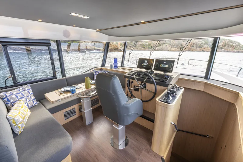 Slide: The Image of Interior of 2026 Beneteau Swift Trawler 54, featuring helm, seating, and panoramic windows. - 8