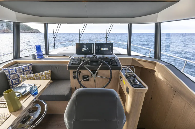 Slide: The Image of Interior of 2026 Beneteau Swift Trawler 54, featuring helm, seating, and ocean view. - 9