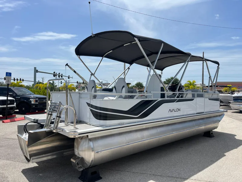 Slide: The Image of 2025 Avalon 2385 Venture 85 Tri Toon boat with canopy, parked outdoors. - 5
