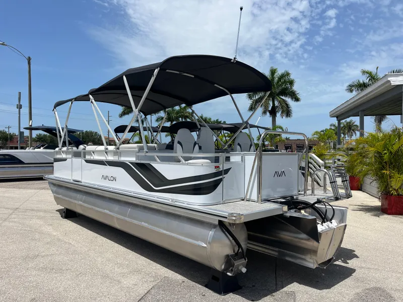 Slide: The Image of 2025 Avalon 2385 Venture 85 Tri Toon boat with canopy, parked outdoors. - 7