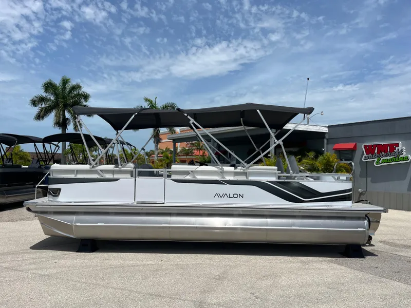 Slide: The Image of 2025 Avalon 2385 Venture 85 Tri Toon boat with canopy, parked outdoors. - 8