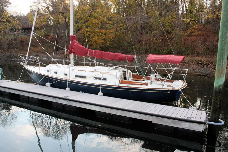 Slide: The Image of 1976 Bristol 34 sailboat docked on calm water with autumn trees in background. - 15