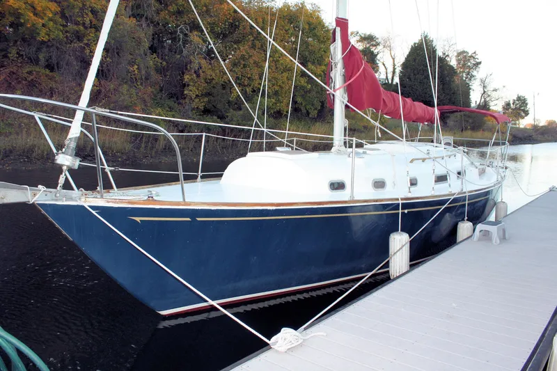 Slide: The Image of 1976 Bristol 34 sailboat docked with red sail and blue hull. - 16