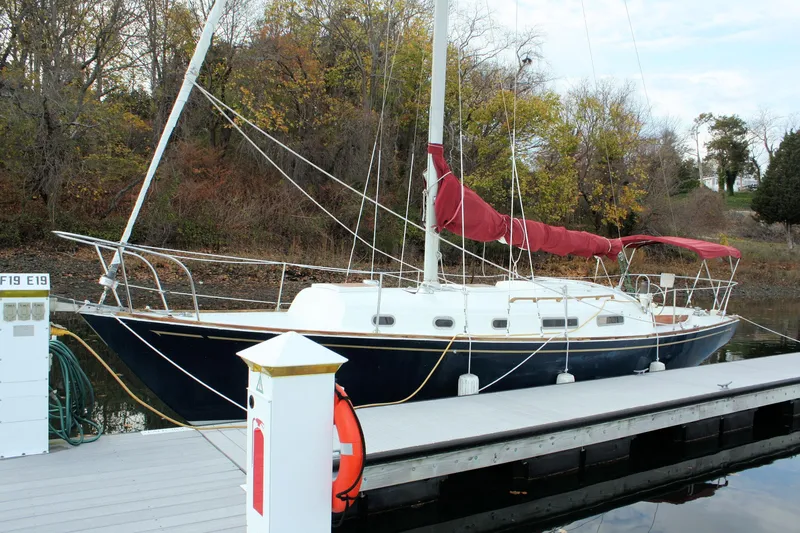 Slide: The Image of 1976 Bristol 34 sailboat docked, featuring a sleek design and red sail cover. - 18
