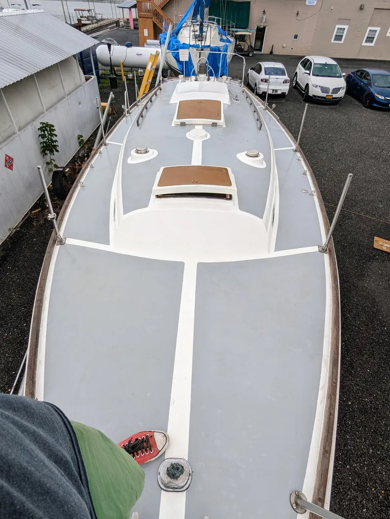 Slide: The Image of 1976 Bristol 34 sailboat deck view in a marina with surrounding vehicles. - 2